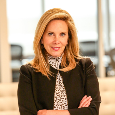 Headshot of Laura Gillen in a black blazer and a print shirt.